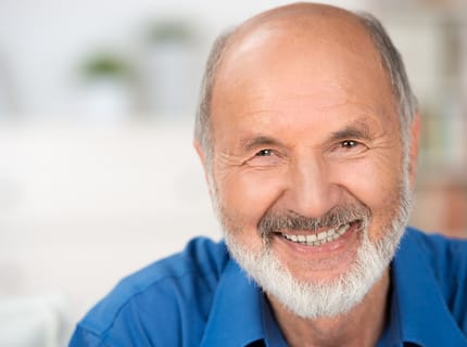 smiling man with implant supported dentures